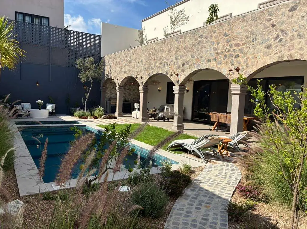Stone-walled courtyard with a rectangular pool, arched colonnade, and lounge chairs nearby, San Miguel de Allende