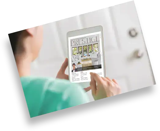Person holding a tablet that displays a magazine cover titled Prestige.