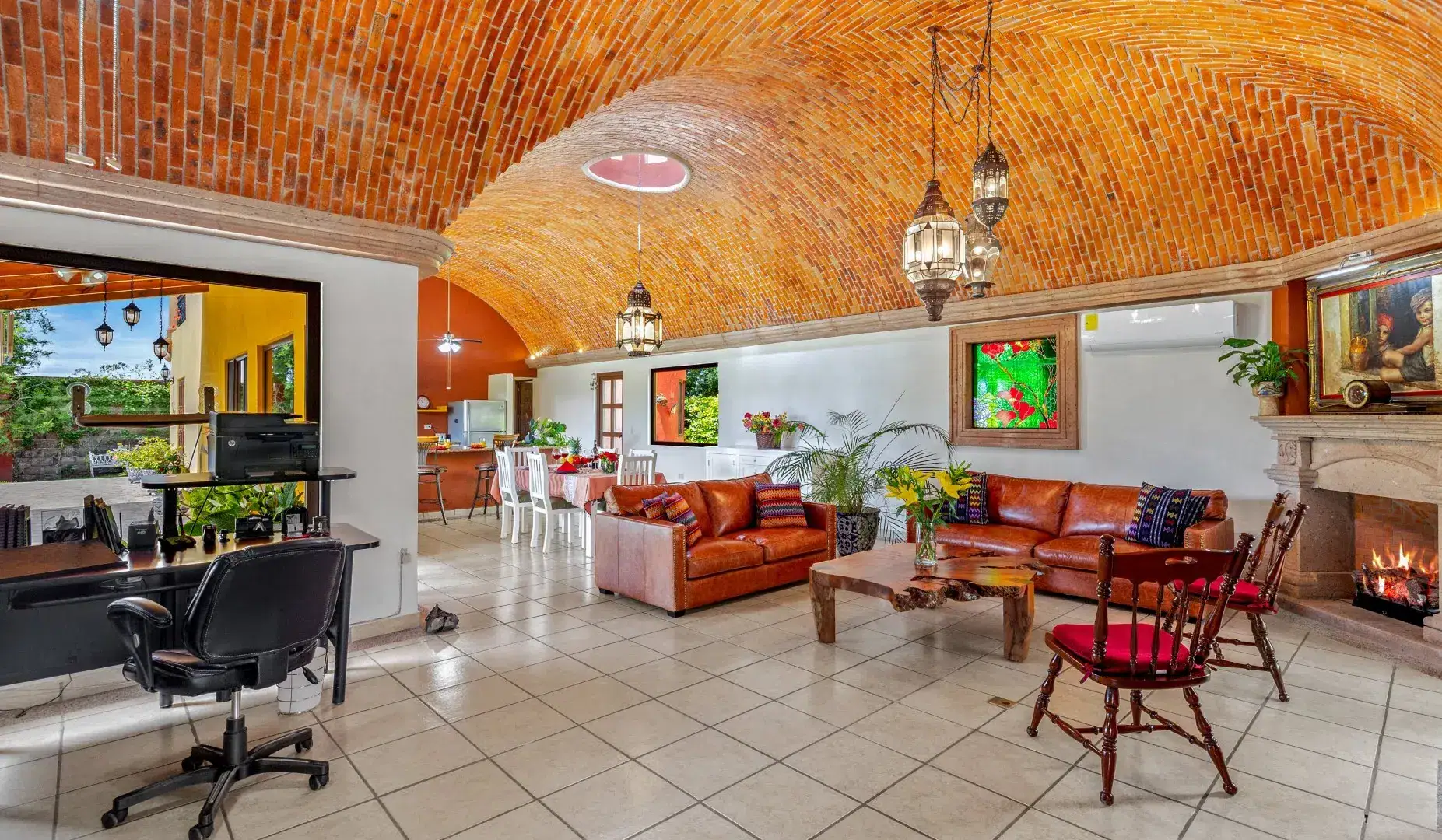 Open living area with a brick vaulted ceiling, red leather sofas, a wooden coffee table, and tiled flooring, San Miguel de Allende