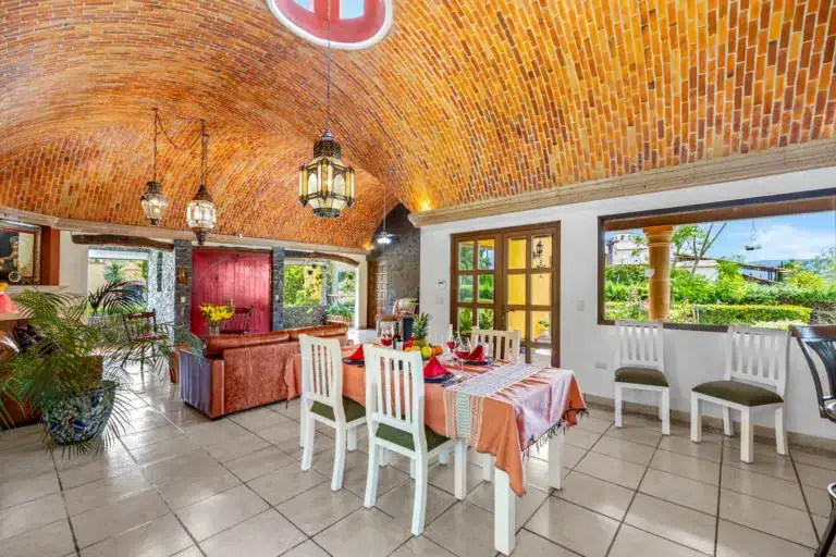 Dining room with a brick vaulted ceiling, hanging lanterns, and a long table set for a meal indoors, San Miguel de Allende