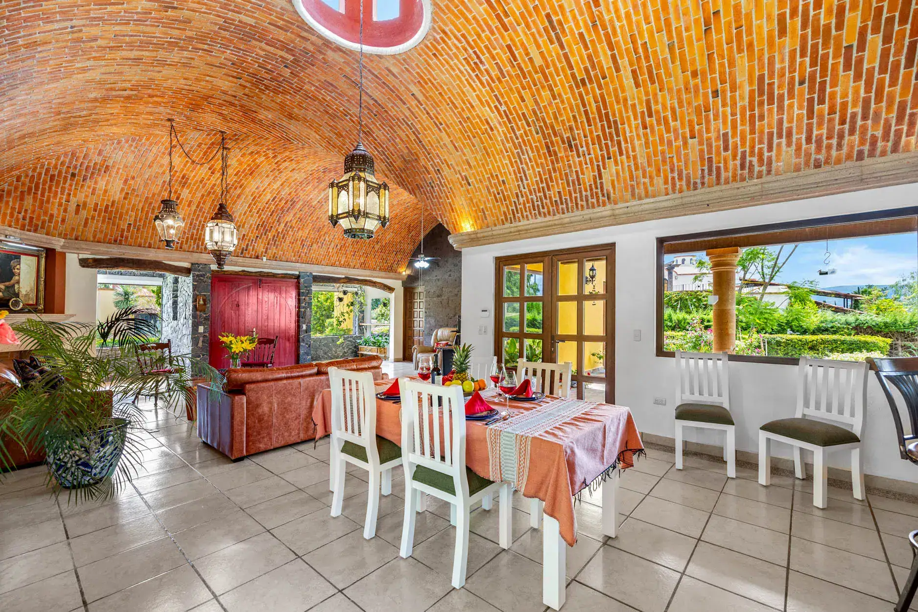 Dining room with a brick vaulted ceiling, hanging lanterns, and a long table set for a meal indoors, San Miguel de Allende