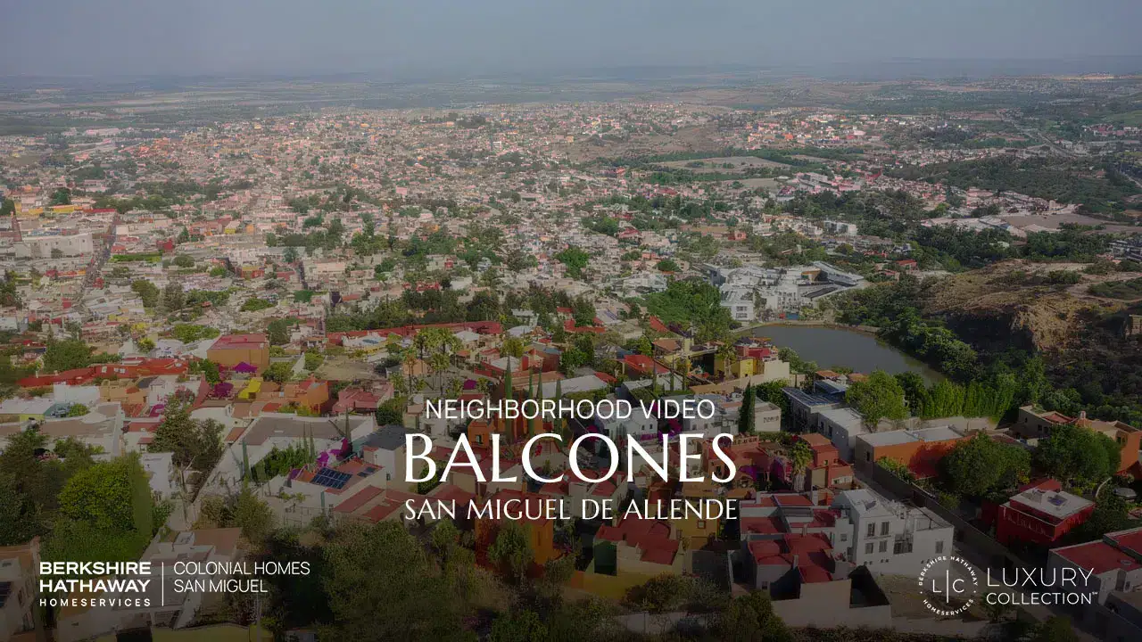 Aerial view of a colorful city with a river and hills, overlaid with text: Neighborhood Video, Balcones, San Miguel de Allende (luxury collection)