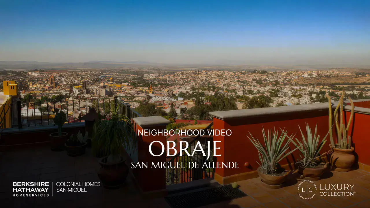 Terrace with potted plants overlooking a cityscape of San Miguel de Allende; overlay text promotes a neighborhood video for Obraje (Berkshire Hathaway Luxury Collection).