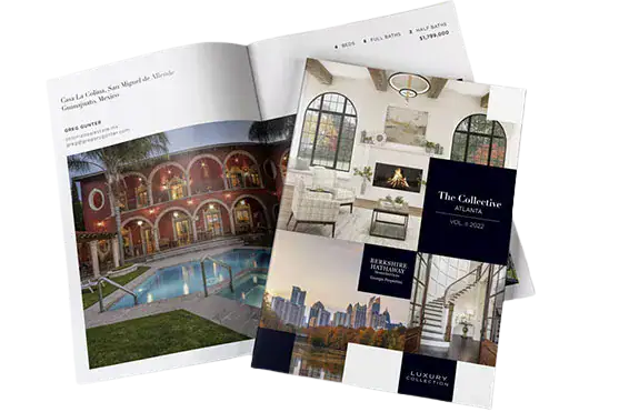 Stack of luxury interior design magazines featuring a poolside courtyard and modern living room spread.