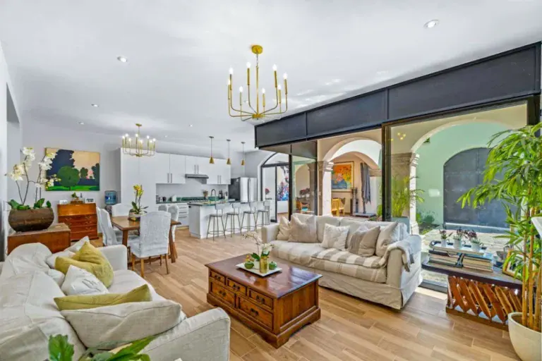 Casa Angel, living room with cream sofas, a wooden coffee table and glass doors to the courtyard, San Miguel de Allende
