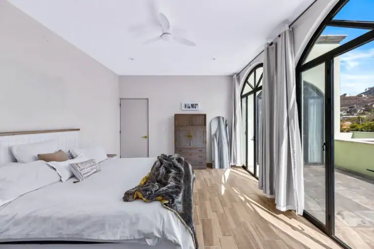 Casas Angel & Angelito, primary bedroom with arched glass doors to the terrace, San Miguel de Allende