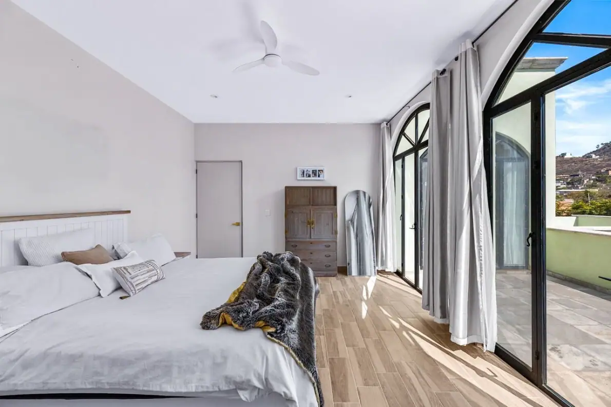 Casas Angel & Angelito, primary bedroom with arched glass doors to the terrace, San Miguel de Allende