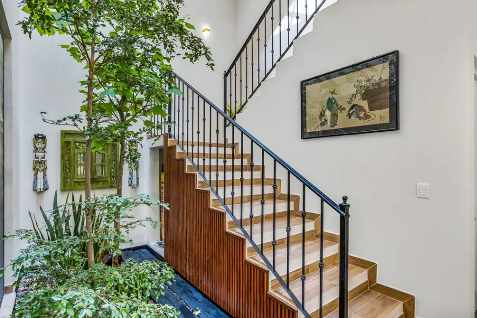 Casa Angel, staircase with iron railings beside a planted atrium, San Miguel de Allende