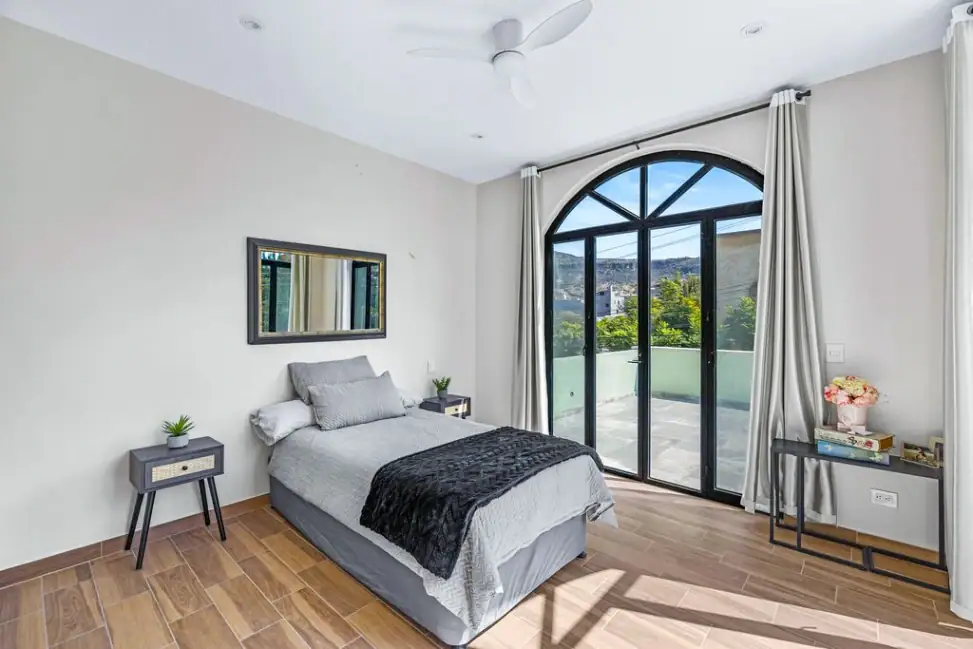 Casa Angel, upstairs bedroom with an arched glass door opening to the roof terrace, San Miguel de Allende
