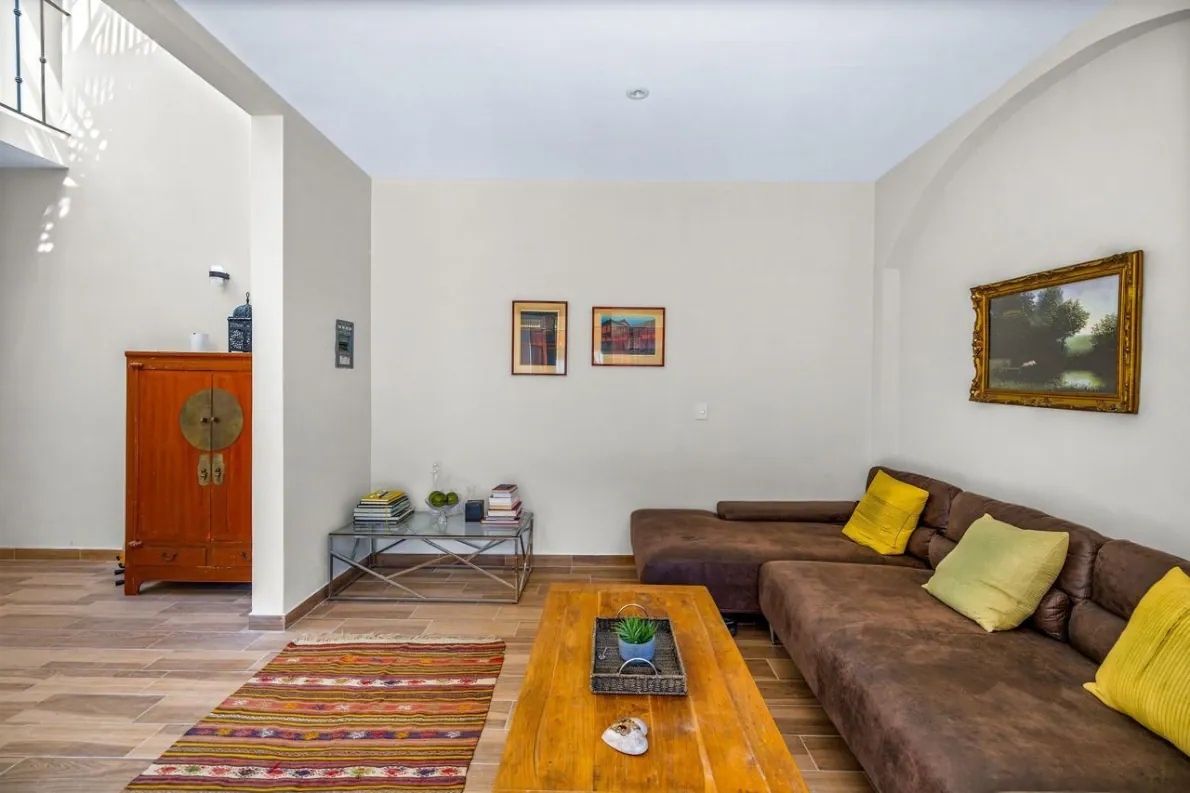 Casas Angel & Angelito, living room with a brown sectional and a wooden coffee table, San Miguel de Allende