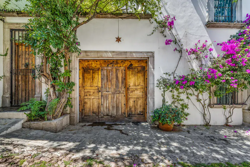 Casa Clae, entrance with a carved wooden door and bougainvillea, San Miguel de Allende