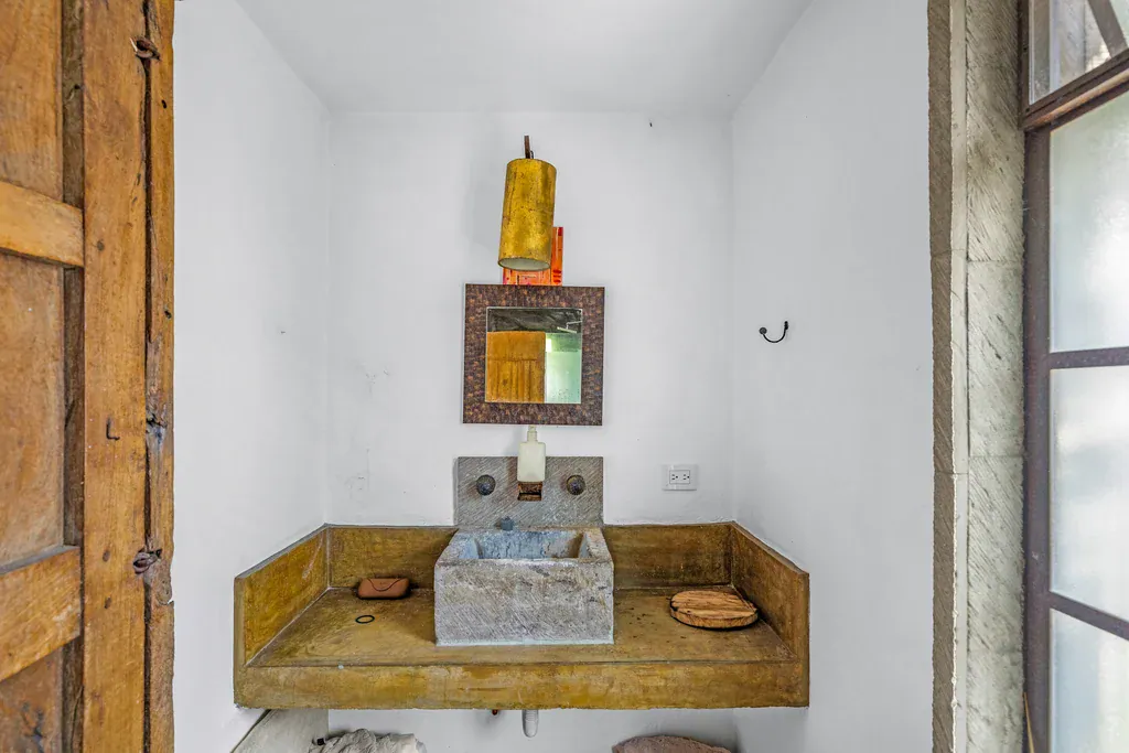 Casa Clae, half bath with a stone sink and a framed mirror, San Miguel de Allende