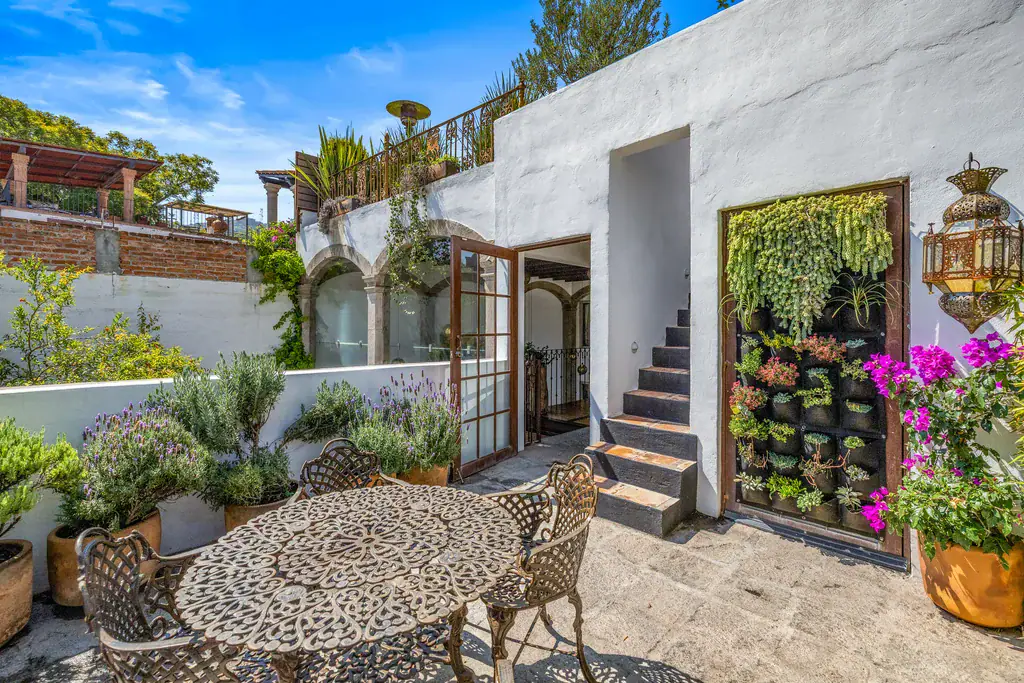Casa Clae, terrace with a round table, a living wall and steps to the upper level, San Miguel de Allende