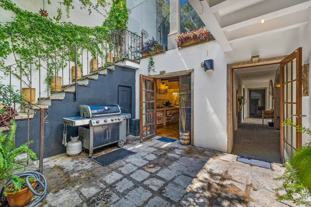 Casa Clae, courtyard entry with an outdoor grill and open doors into the house, San Miguel de Allende