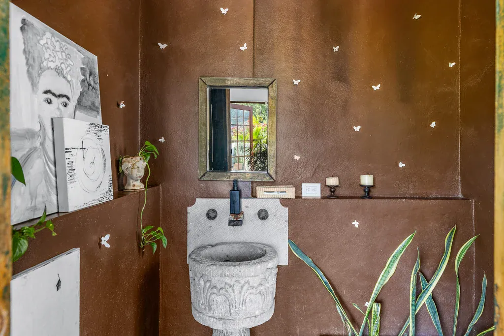Casa Clae, powder room with a carved stone basin and a brown plaster wall, San Miguel de Allende