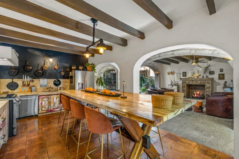 Casa Clae, kitchen and dining area with a wood table, beamed ceiling and a fireplace sitting area, San Miguel de Allende