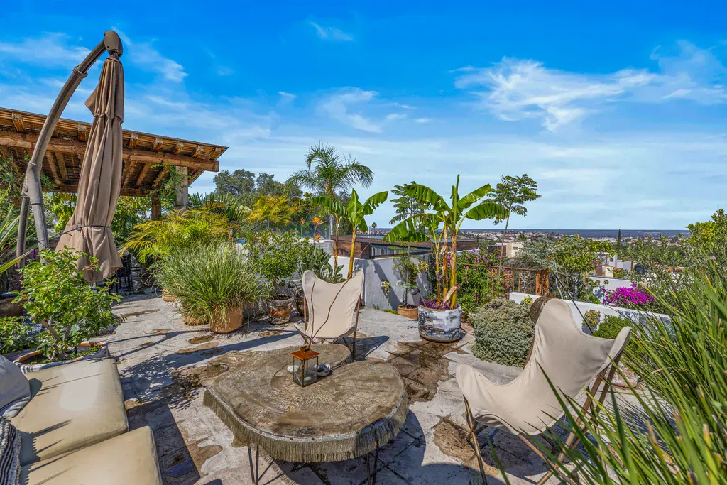 Casa Clae, roof terrace with a stone coffee table, butterfly chairs and views over the town, San Miguel de Allende