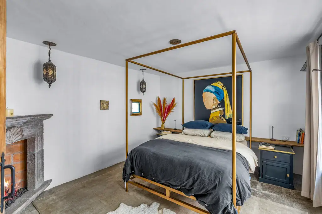 Casa Clae, bedroom with a four-poster bed and a corner fireplace, San Miguel de Allende