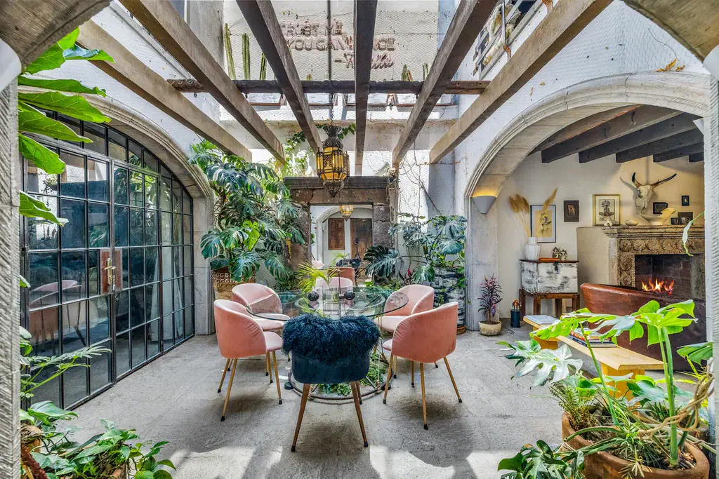 Casa Clae, indoor garden room with glass walls, pink chairs and plants, San Miguel de Allende