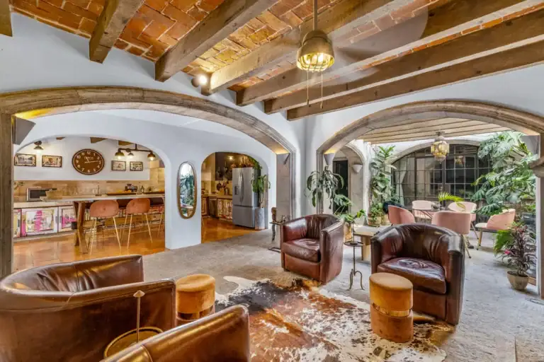 Casa Clae, living area with leather chairs, a vaulted brick ceiling and the kitchen beyond, San Miguel de Allende