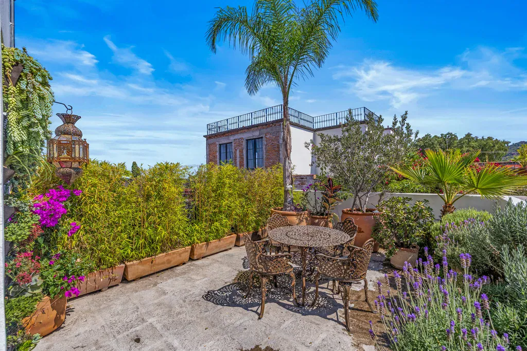 Casa Clae, garden terrace with a wrought-iron table, lavender and a palm tree, San Miguel de Allende