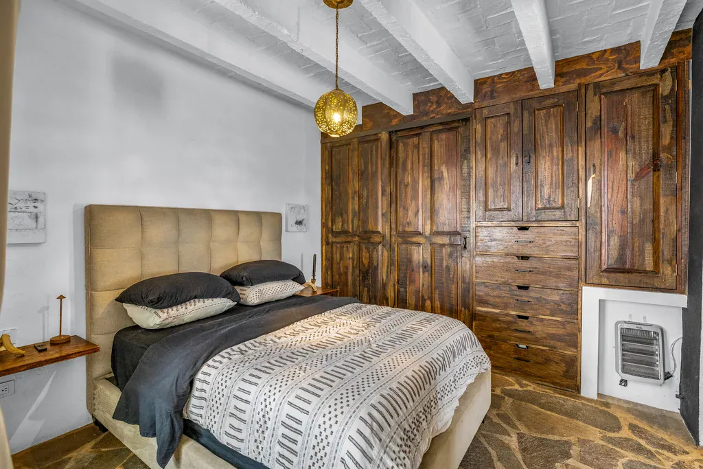 Casa Clae, bedroom with built-in rustic wood wardrobes and a platform bed, San Miguel de Allende