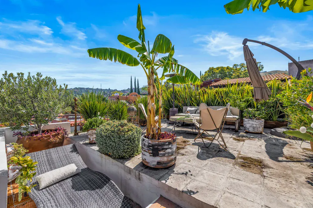 Casa Clae, roof terrace with lounge chairs, banana plants and a shade umbrella, San Miguel de Allende