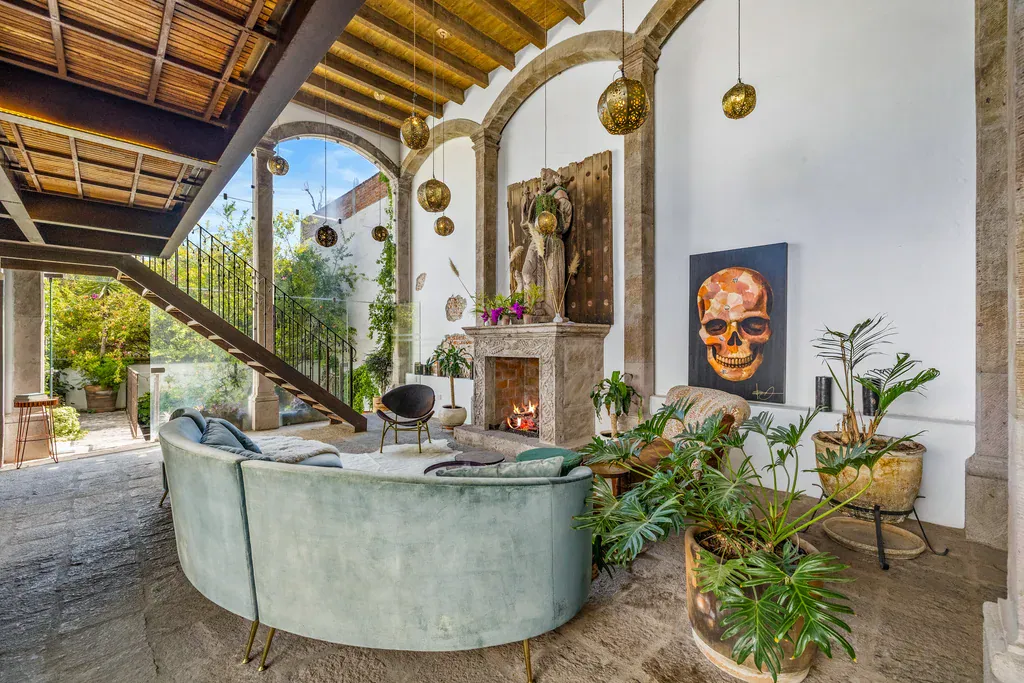 Casa Clae, living room with a fireplace, a staircase and potted plants, San Miguel de Allende