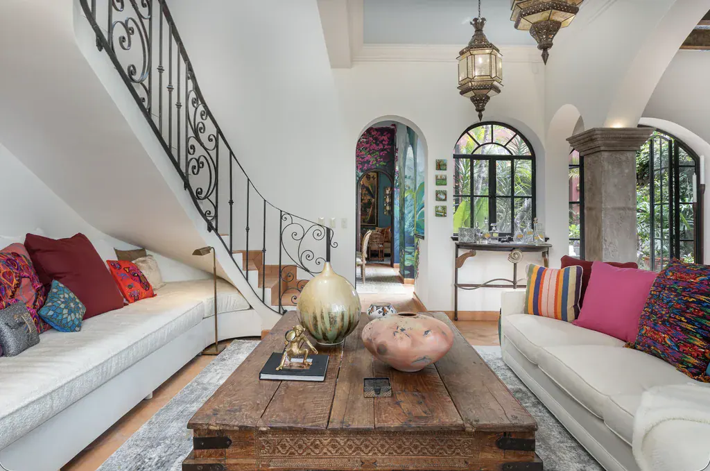 Casa del Arroyo, living room with a wrought-iron staircase and a rustic wood coffee table, San Miguel de Allende