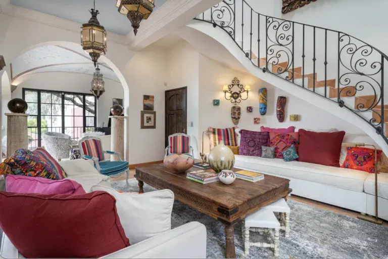 Casa del Arroyo, living room with a wrought-iron staircase and colorful cushions, San Miguel de Allende