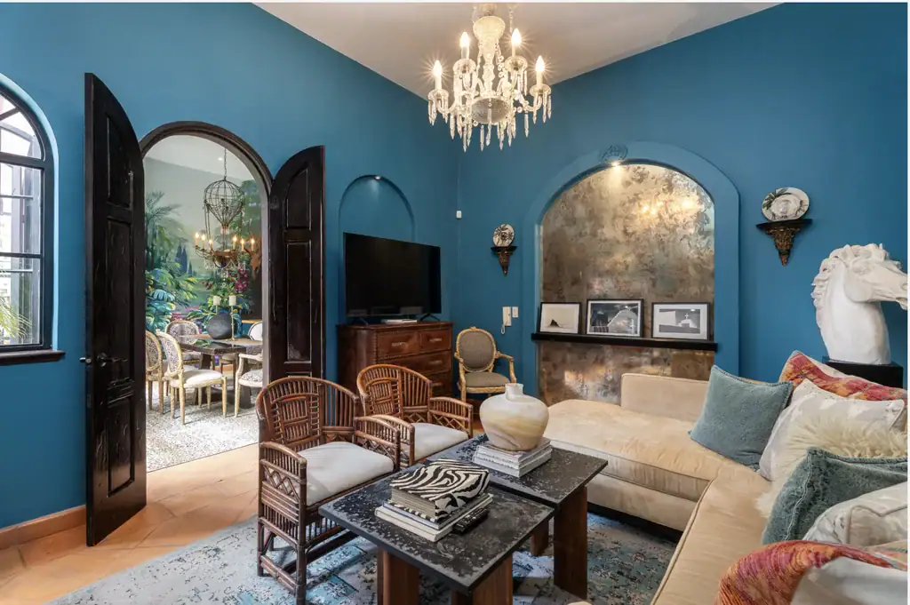 Casa del Arroyo, blue living room with a beige sectional and wicker chairs, San Miguel de Allende