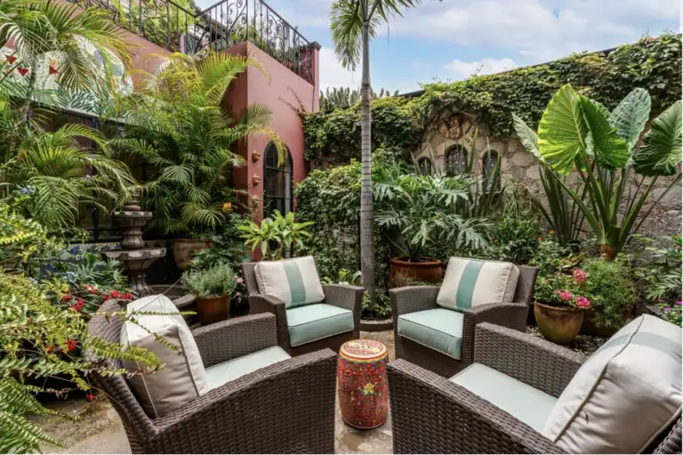 Casa del Arroyo, shaded garden courtyard with wicker seating and tropical plants, San Miguel de Allende