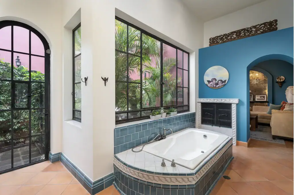 Casa del Arroyo, bathroom with a tiled soaking tub and an arched garden door, San Miguel de Allende