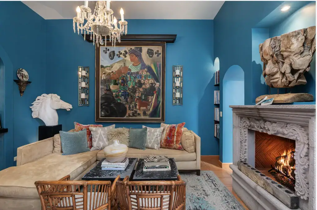 Casa del Arroyo, blue living room with a carved stone fireplace and a large painting, San Miguel de Allende