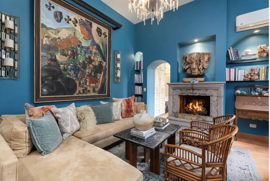 Casa del Arroyo, blue living room with a stone fireplace and a large painting, San Miguel de Allende