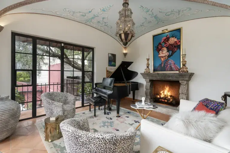 Casa del Arroyo, sitting room with a grand piano, stone fireplace and painted vaulted ceiling, San Miguel de Allende