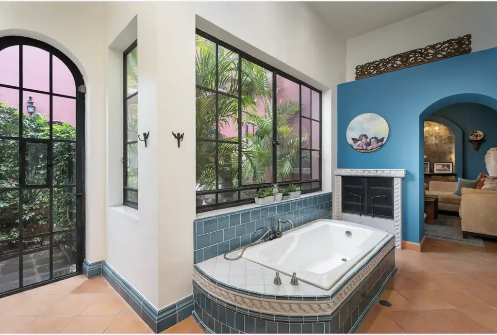 Casa del Arroyo, bathroom with a soaking tub and an arched steel-framed door to the garden, San Miguel de Allende