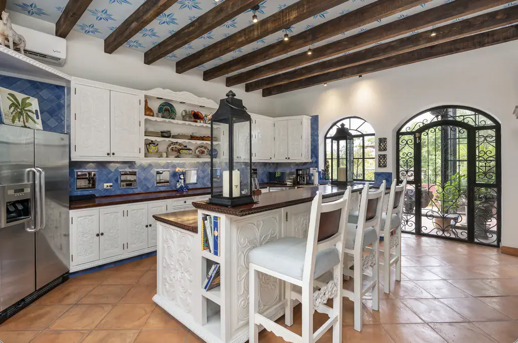 Casa del Arroyo, kitchen with a bar-stool island and a beamed, painted ceiling, San Miguel de Allende