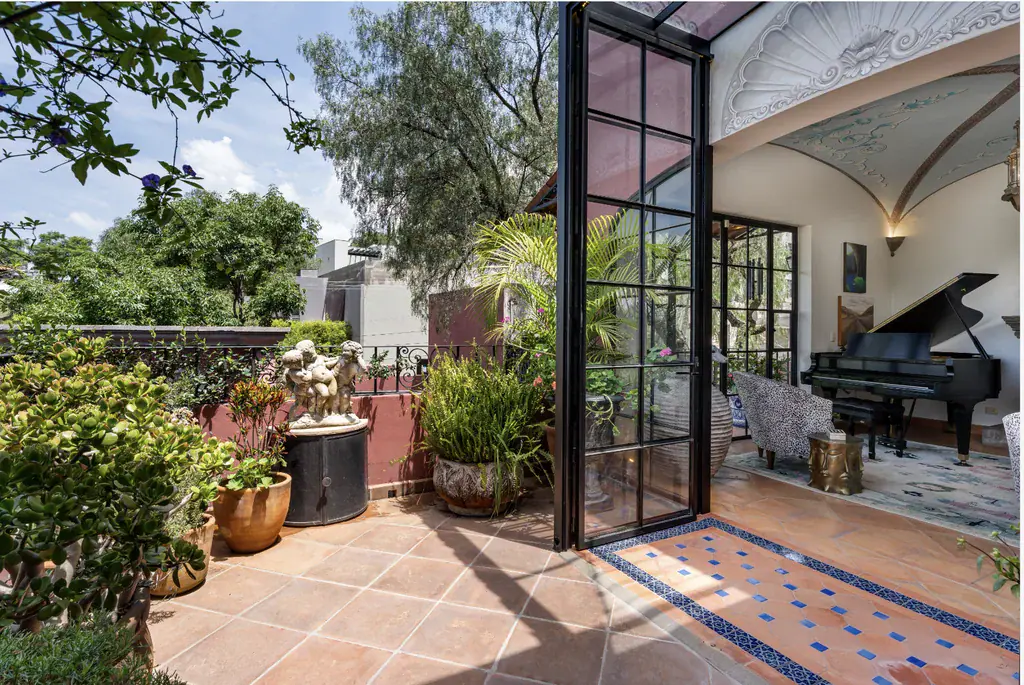 Casa del Arroyo, terrace with potted plants beside open steel-framed doors, San Miguel de Allende