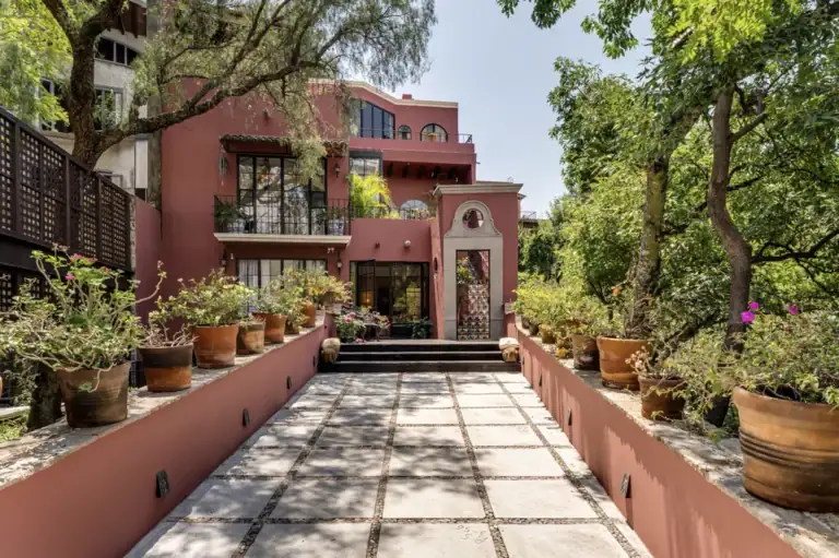 Casa del Arroyo, terracotta-colored facade above a paved garden terrace, San Miguel de Allende