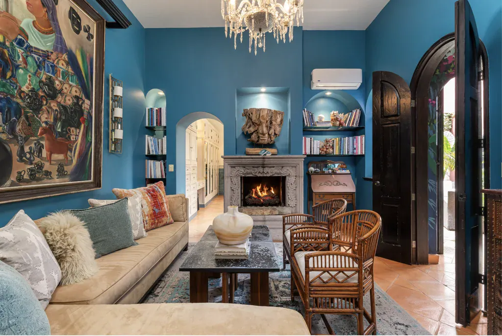 Casa del Arroyo, blue living room with a stone fireplace and built-in shelves, San Miguel de Allende