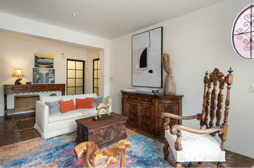 Casa del Arroyo, sitting room with a white sofa and a carved wood chair, San Miguel de Allende
