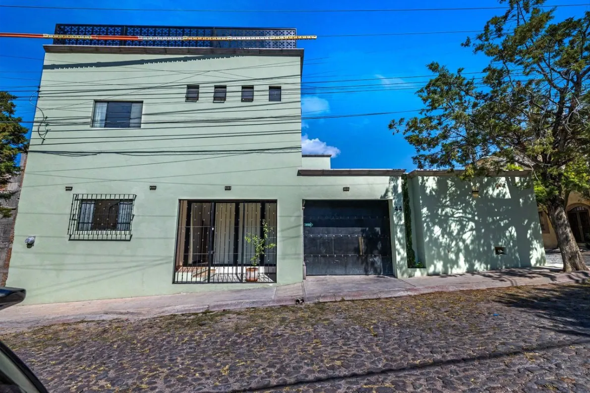 Casas Angel & Angelito, pale green street facade with a garage door, San Miguel de Allende