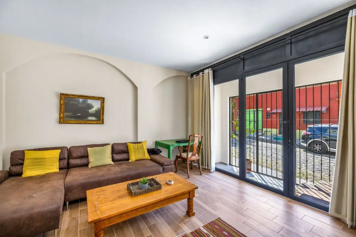 Casas Angel & Angelito, living room with a sectional and glass doors to the street, San Miguel de Allende