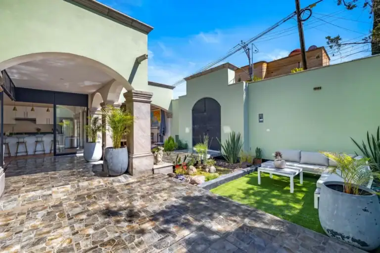 Casas Angel & Angelito, courtyard with a lawn, lounge seating and an arched portico, San Miguel de Allende