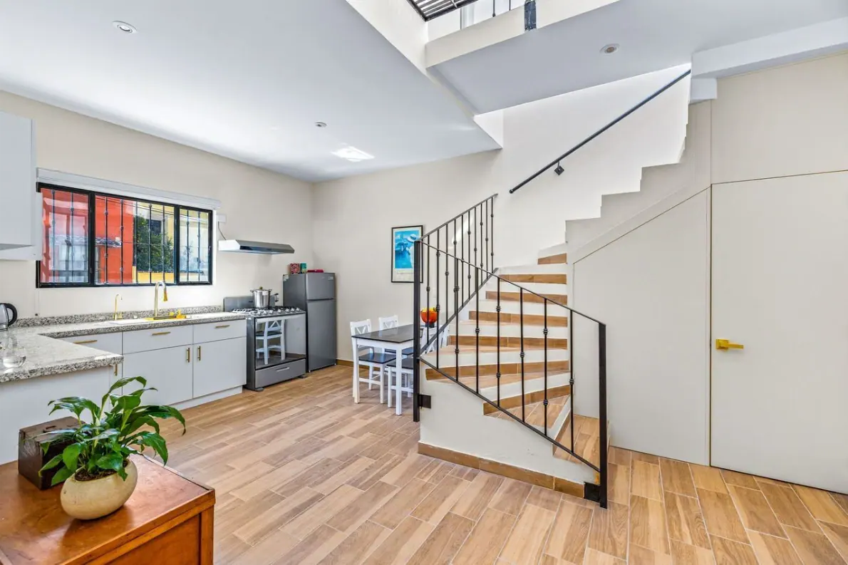 Casas Angel & Angelito, kitchen with white cabinets and a staircase, San Miguel de Allende