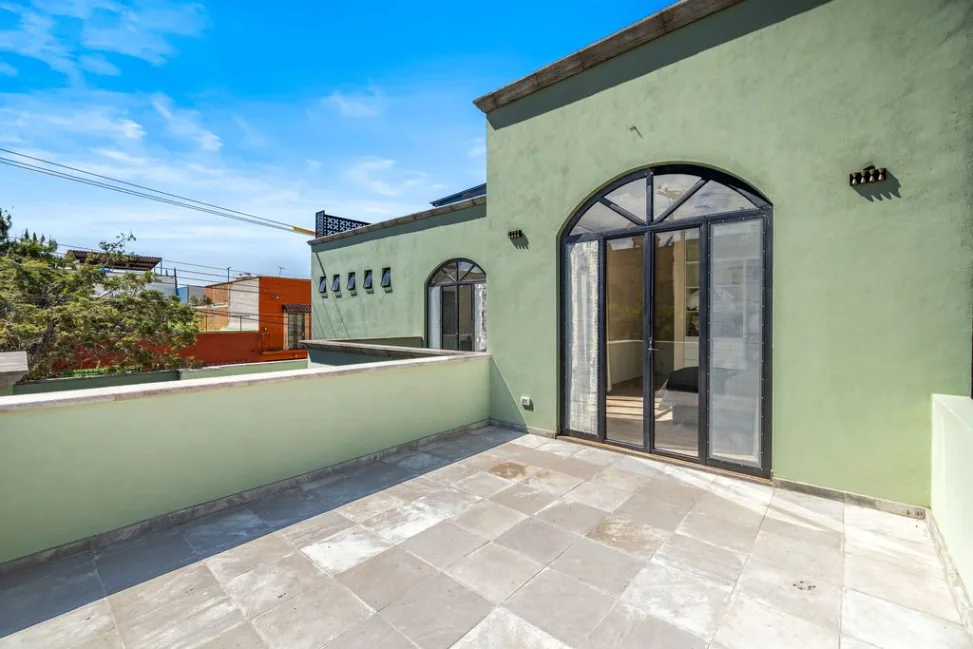 Casa Angel, roof terrace with stone paving and arched glass doors, San Miguel de Allende