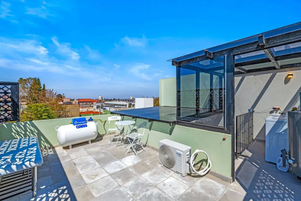 Casas Angel & Angelito, roof terrace with a glass skylight structure and bistro tables, San Miguel de Allende