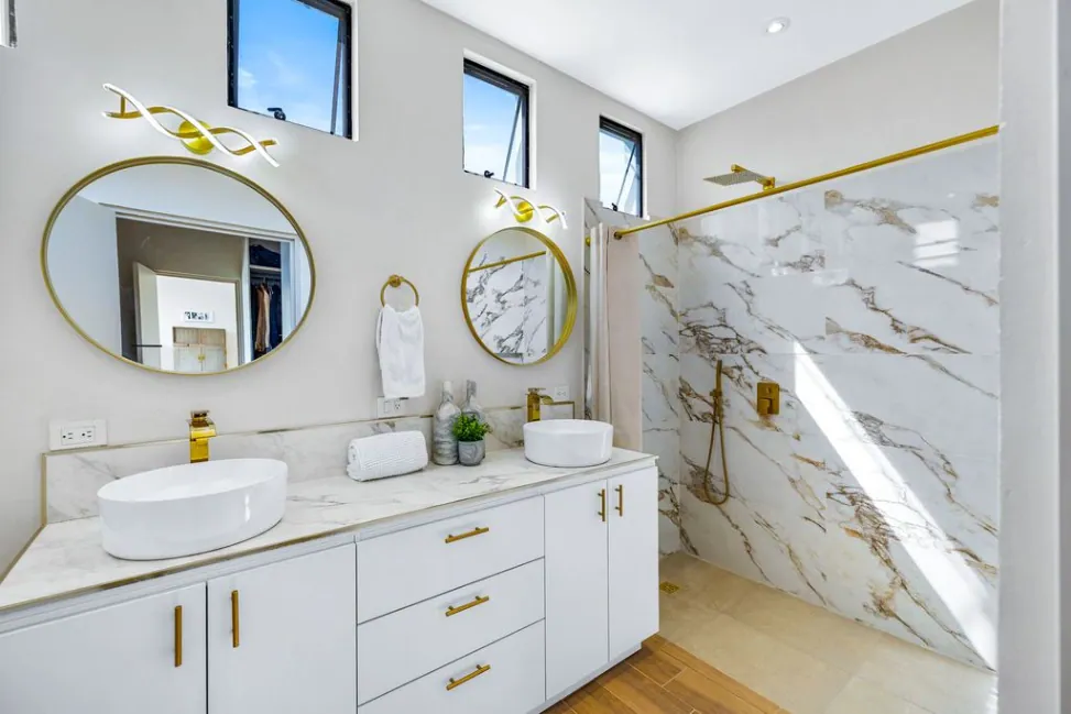 Casa Angel, primary bathroom with double vessel sinks, round mirrors and a marble shower, San Miguel de Allende