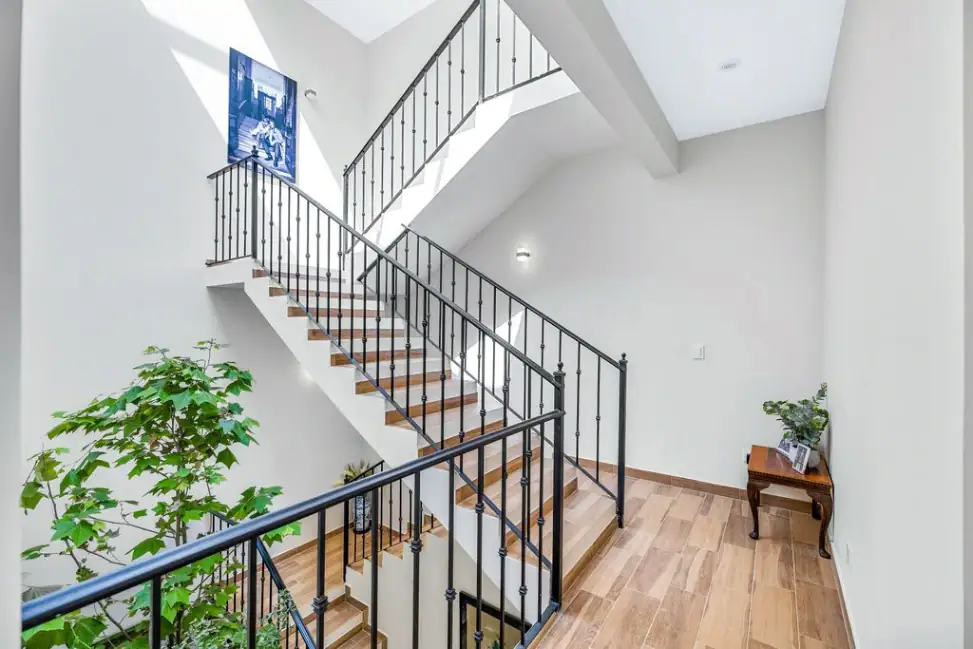Casa Angel, staircase seen from above with iron railings and a planted atrium, San Miguel de Allende